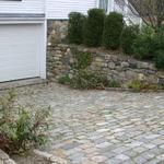 Aged cobblestone (Belgian Block) ramp with channel drain and fieldstone retaining walls