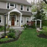 Formal plantings, stone wallk and arbor all add interest to the front entrance view