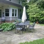 Broken bluestone patio creates an informal sitting area in the back yard