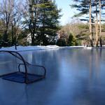 Combination ice skating rink and granite edged asphalt tennis and play court. Removable plugs allow for easy flooding and draining of the ice rink.