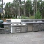 Custom Van Tassel Granite Outdoor Kitchen with honed lilac Bluestone Counter top.  Components include built-in Grill, sink, ice chest, cabinets and Big Green Egg.