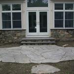 Lilac colored broken bluestone landing and walk.  Fieldstone veneer foundation and step risers with lilac colored bluestone treads and wall cap.