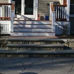 Fieldstone walls and risers with bluestone treads and brick upper landing and broken bluestone patio